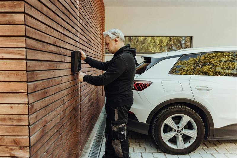 Electrician installing equipment beside a work vehicle
